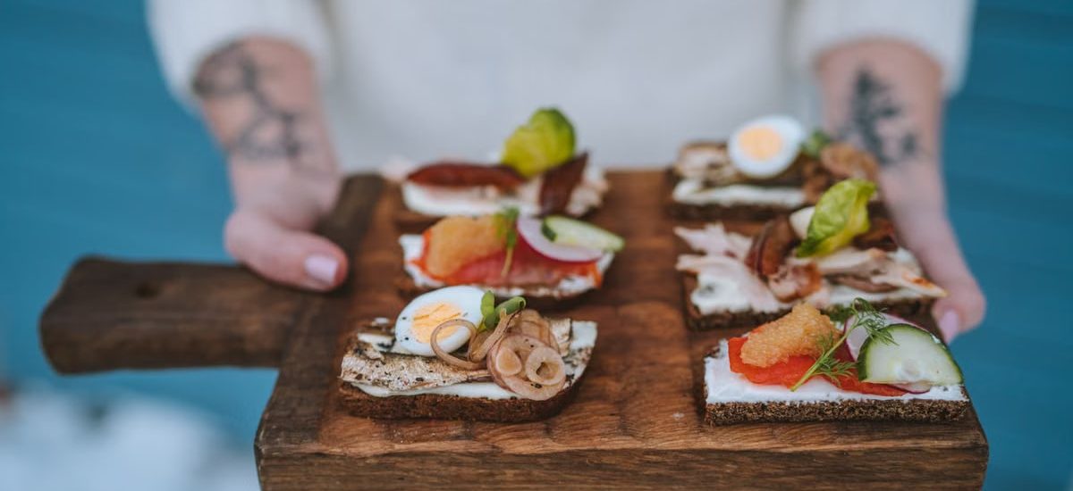 Delicious open-faced sandwiches with various toppings served on a wooden board, showcasing exquisite food styling.