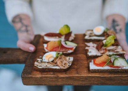 Delicious open-faced sandwiches with various toppings served on a wooden board, showcasing exquisite food styling.